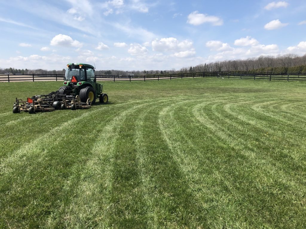 A large riding lawn mower sitting in a field of green grass.