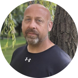 A man standing outside, smiling.