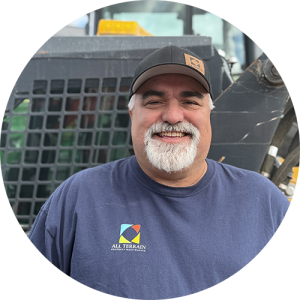 A man standing outside, smiling.