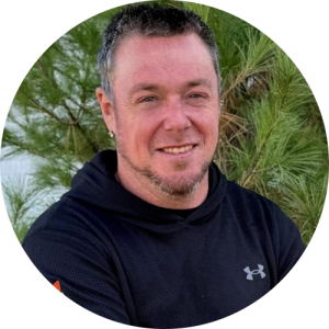 A man standing outside, smiling.