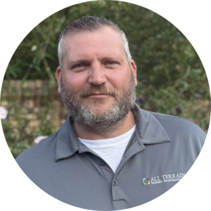 A man standing outside, smiling.