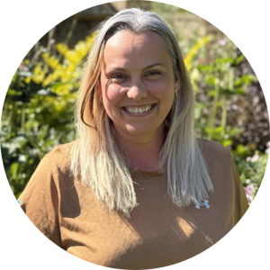 A woman outside, smiling.