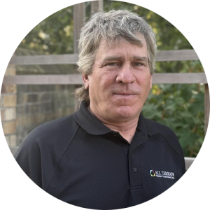 A man standing outside, smiling.