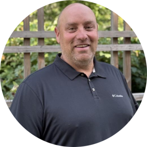 A man standing outside, smiling.